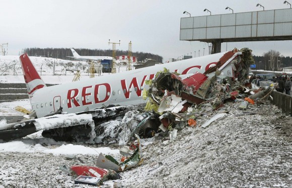 An aircraft wreckage lies next to a highway near Moscow's Vnukovo Airport